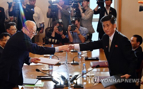 박경서 대한적십자사 회장(왼쪽)과 박용일 조국평화통일위원회 부위원장이 8월 20∼26일 금강산에서 남북 이산가족 상봉행사를 개최하기로 합의한 공동보도문을 들고 악수하고 있다.    연합뉴스